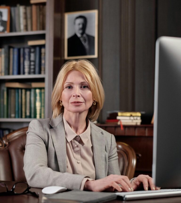 Mature businesswoman at desk in office, portraying leadership and professionalism.